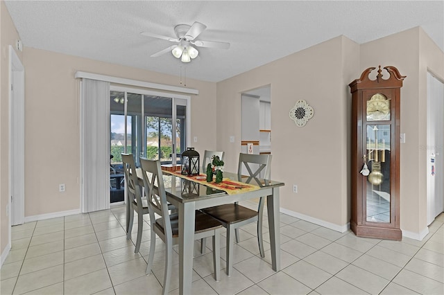 dining area featuring ceiling fan, light tile patterned flooring, and a textured ceiling