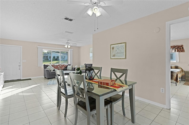 tiled dining space featuring ceiling fan and a textured ceiling