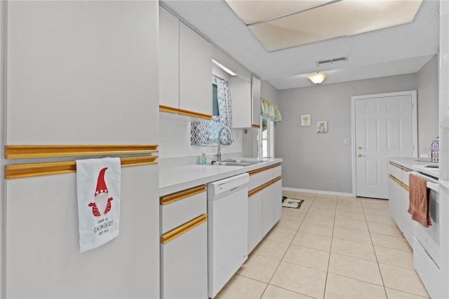 kitchen featuring white cabinets, light tile patterned floors, white dishwasher, and sink