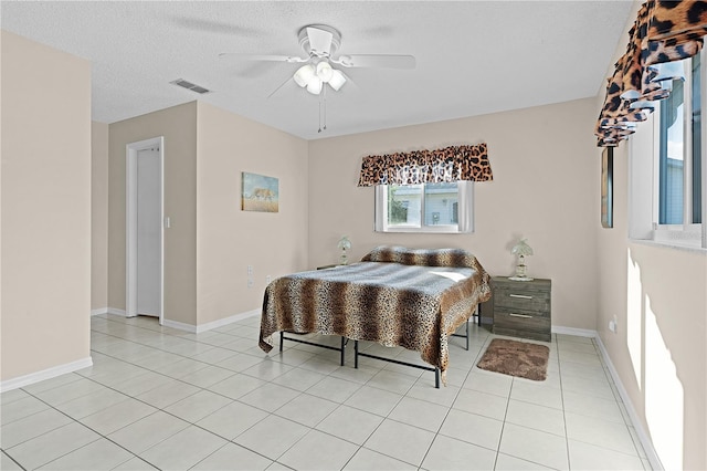 tiled bedroom featuring a textured ceiling and ceiling fan