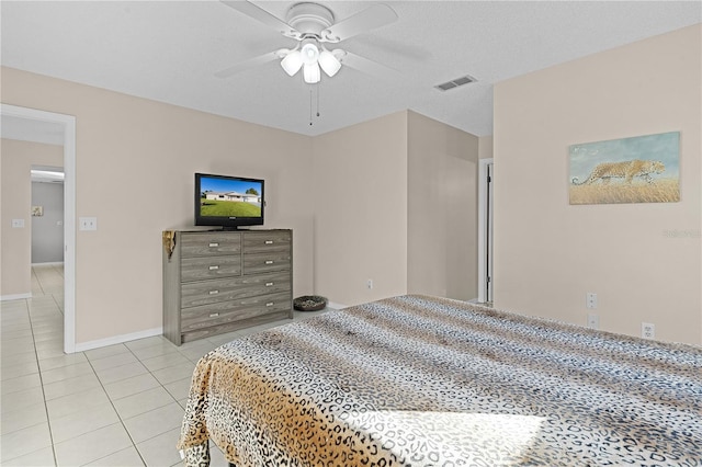 tiled bedroom featuring ceiling fan and a textured ceiling