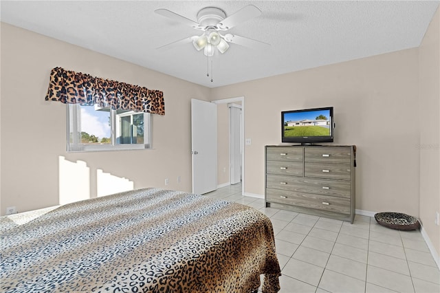 tiled bedroom featuring ceiling fan and a textured ceiling