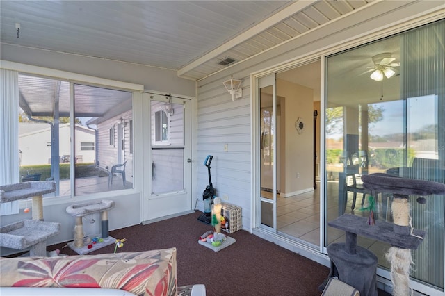 sunroom / solarium with ceiling fan, a baseboard heating unit, a wealth of natural light, and vaulted ceiling