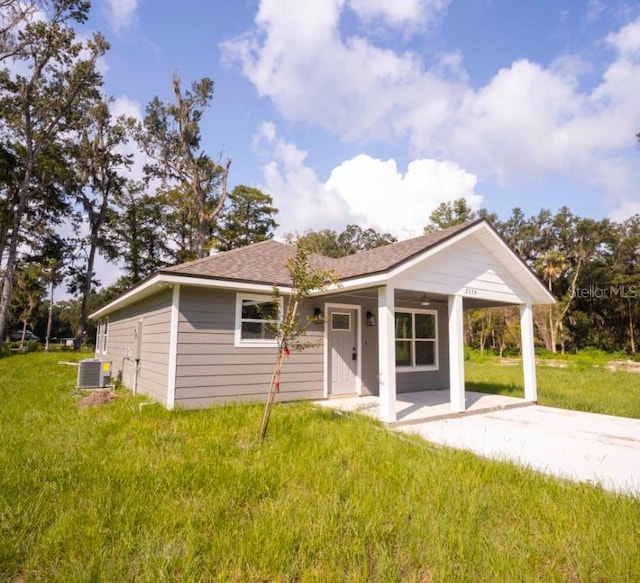 ranch-style house with central AC unit and a front yard