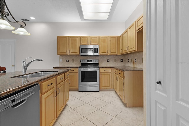 kitchen with decorative backsplash, sink, stainless steel appliances, and decorative light fixtures