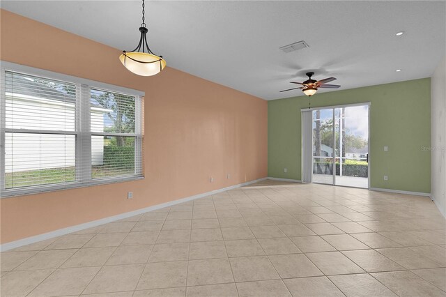 empty room with ceiling fan and light tile patterned flooring