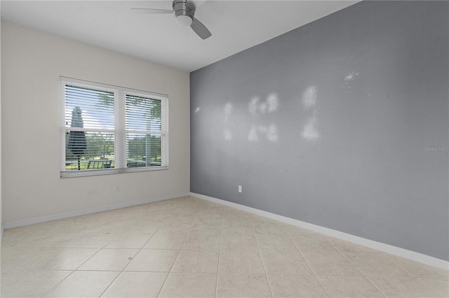 tiled spare room featuring ceiling fan