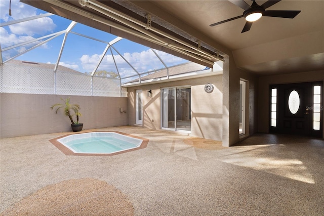 view of swimming pool featuring glass enclosure, ceiling fan, a patio area, and a hot tub