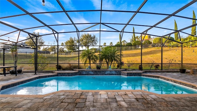 view of swimming pool with glass enclosure and a patio area