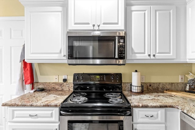 kitchen featuring white cabinets, appliances with stainless steel finishes, and light stone counters