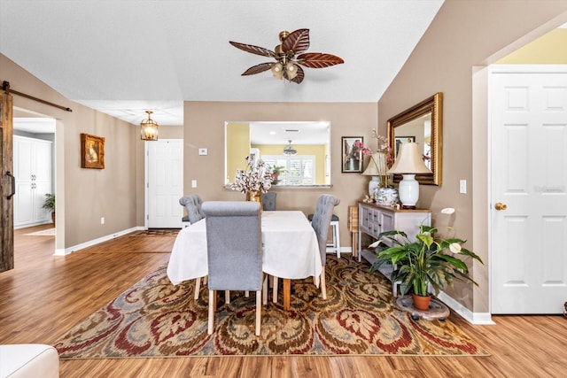 dining room with hardwood / wood-style flooring, a textured ceiling, lofted ceiling, and ceiling fan