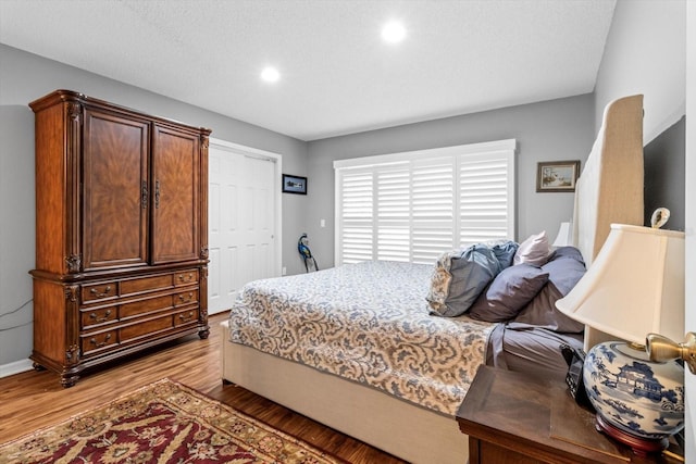 bedroom with a textured ceiling and light hardwood / wood-style flooring