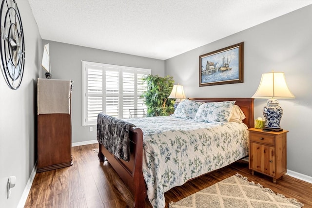 bedroom featuring a textured ceiling and dark hardwood / wood-style floors