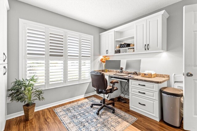 603 San Pedro Dr, The Villages, FL 32159 - office featuring built in study area, wood finished floors, a textured ceiling, and baseboards