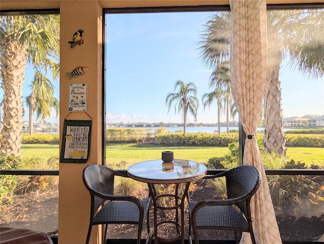 sunroom / solarium featuring a water view