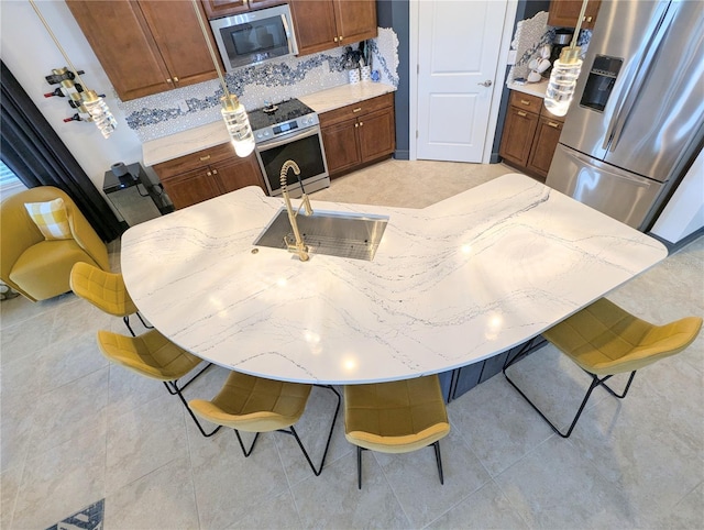 kitchen with decorative backsplash, light tile patterned floors, and stainless steel appliances