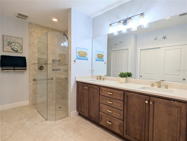 bathroom featuring tile patterned flooring, vanity, and a tile shower