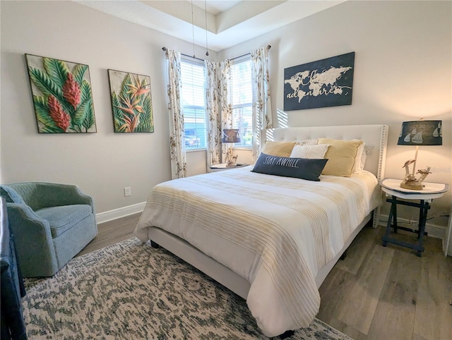 bedroom featuring a tray ceiling and dark hardwood / wood-style floors