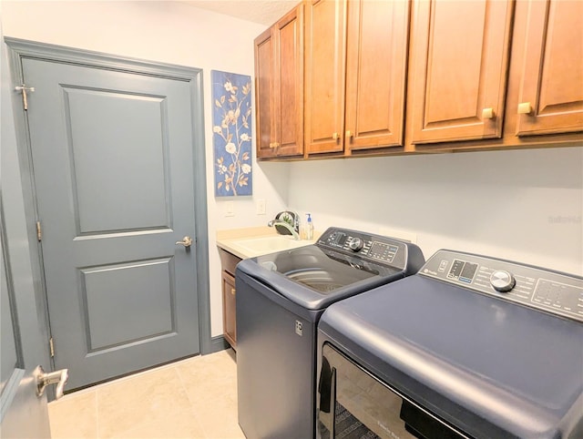 clothes washing area with cabinets, a textured ceiling, sink, light tile patterned floors, and separate washer and dryer