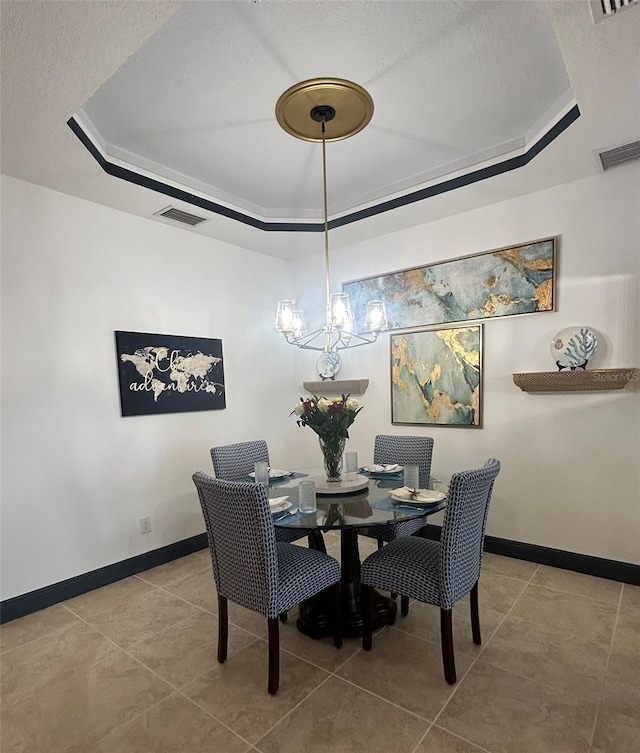 dining area featuring a textured ceiling, a raised ceiling, visible vents, and tile patterned flooring