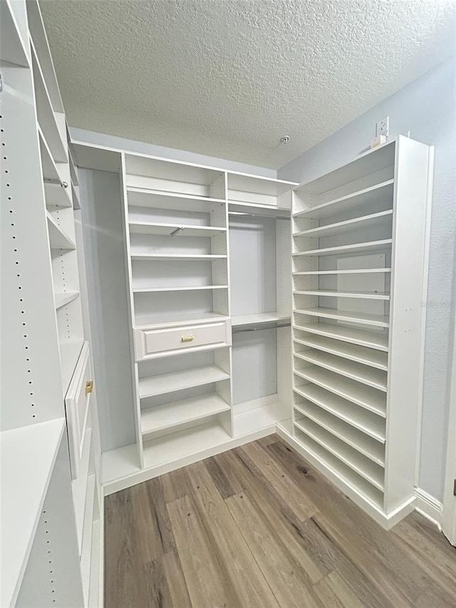 walk in closet with wood finished floors