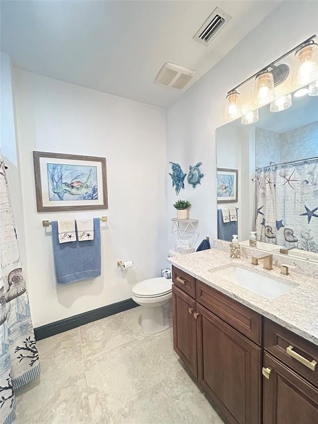 bathroom with toilet, visible vents, vanity, and baseboards