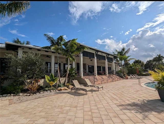 view of patio featuring a ceiling fan and a community pool