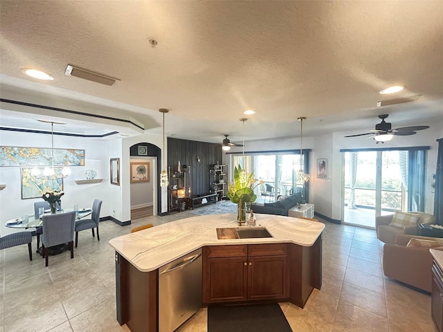 kitchen with stainless steel dishwasher, a ceiling fan, a sink, and open floor plan