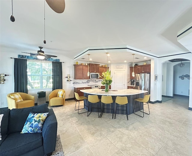 kitchen with a kitchen breakfast bar, appliances with stainless steel finishes, open floor plan, and light countertops