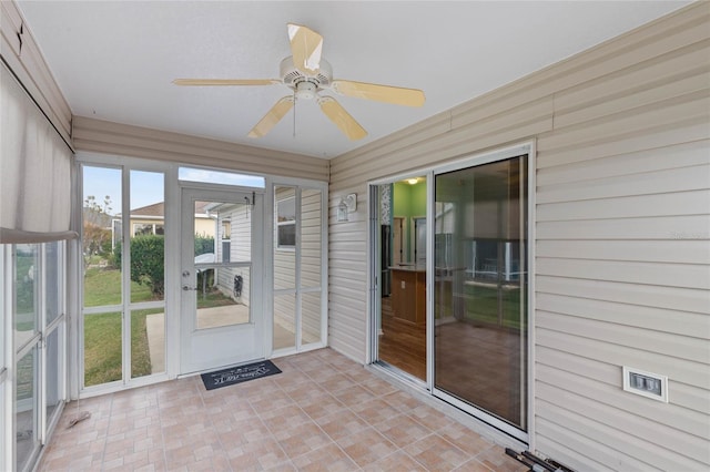 unfurnished sunroom with a ceiling fan