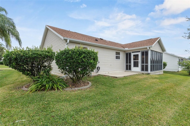 back of property featuring a yard, a patio, and a sunroom