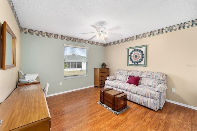 living room featuring a textured ceiling, ceiling fan, and hardwood / wood-style flooring