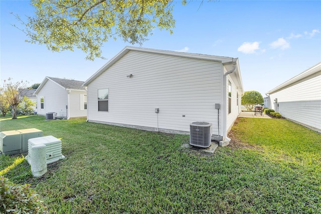 back of property featuring cooling unit and a yard