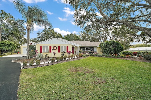 ranch-style house featuring a front lawn and a garage