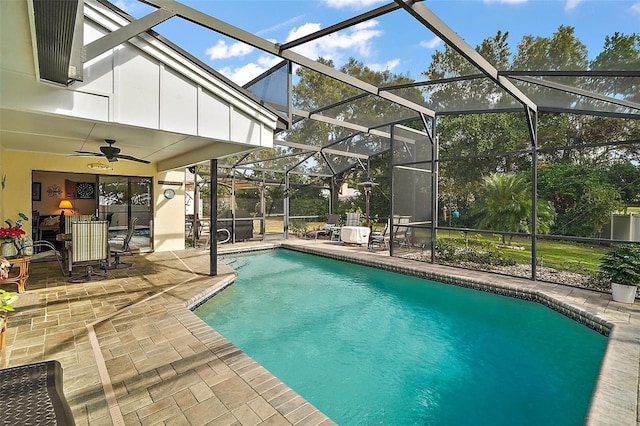 view of pool with glass enclosure, ceiling fan, and a patio area