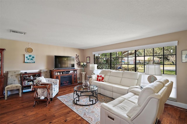 living room featuring dark hardwood / wood-style floors, plenty of natural light, and a fireplace