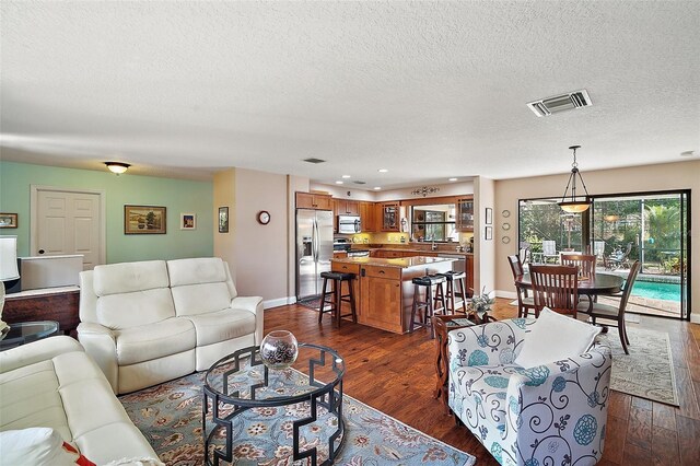 living room with dark wood-type flooring and a textured ceiling