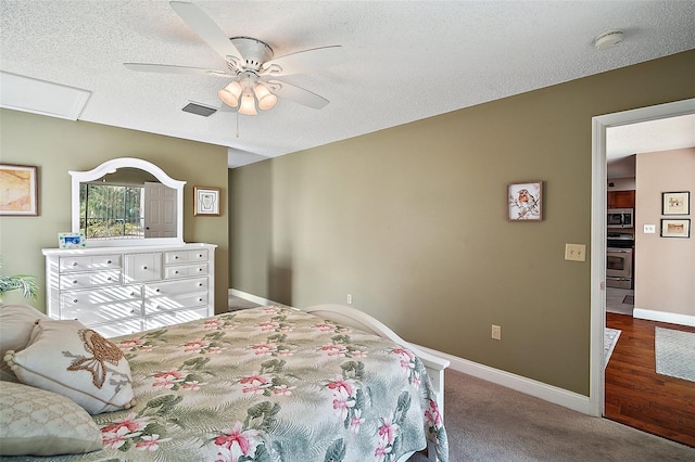 bedroom featuring ceiling fan, carpet floors, and a textured ceiling