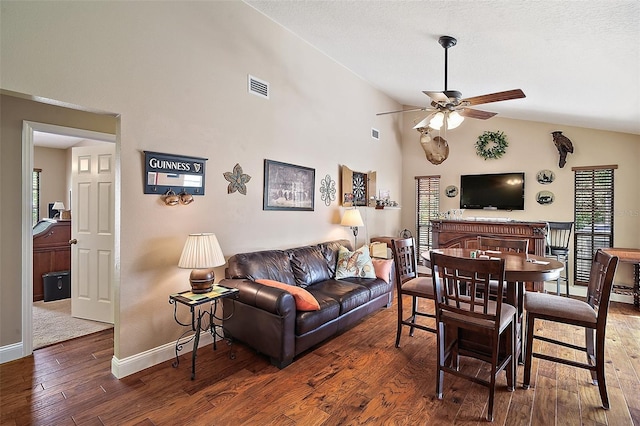 living room featuring ceiling fan, dark wood-type flooring, and lofted ceiling