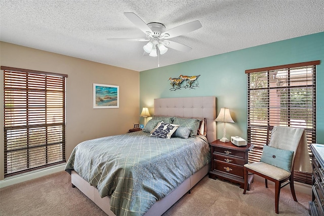 carpeted bedroom featuring ceiling fan, a textured ceiling, and multiple windows