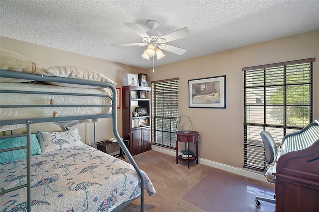 carpeted bedroom featuring ceiling fan and a textured ceiling