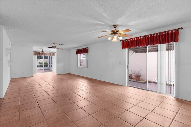 tiled empty room featuring a textured ceiling