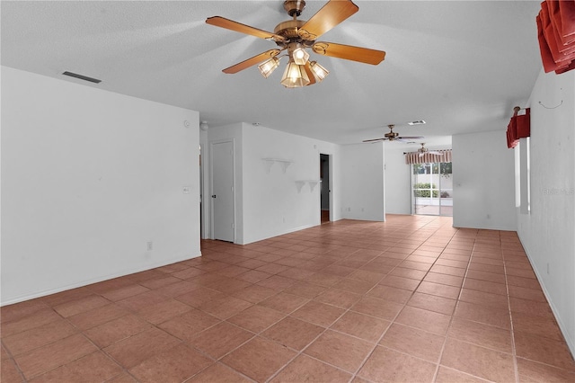 spare room with ceiling fan and light tile patterned flooring