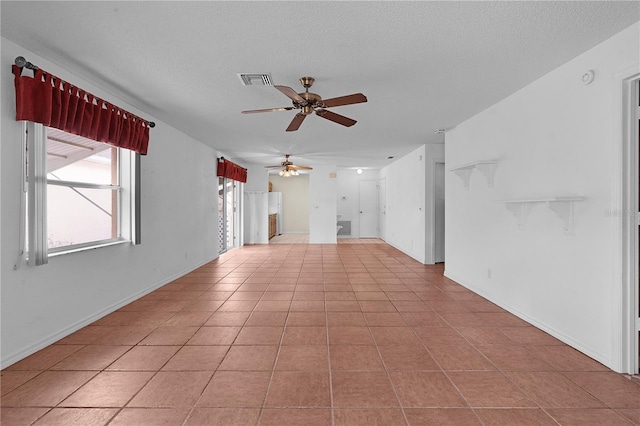 tiled empty room featuring ceiling fan and a textured ceiling