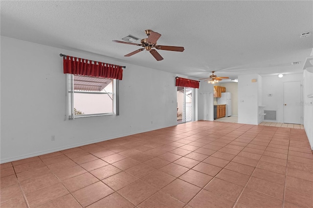 unfurnished living room featuring light tile patterned floors, a textured ceiling, and ceiling fan