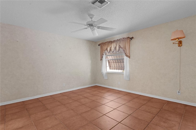 spare room featuring ceiling fan, tile patterned flooring, and a textured ceiling