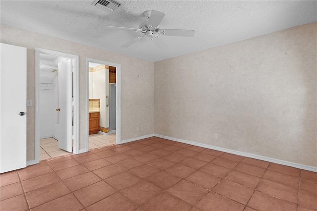 tiled empty room with a textured ceiling and ceiling fan