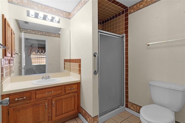 bathroom with tile patterned floors, toilet, an enclosed shower, and vanity