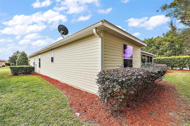 view of side of home with a yard