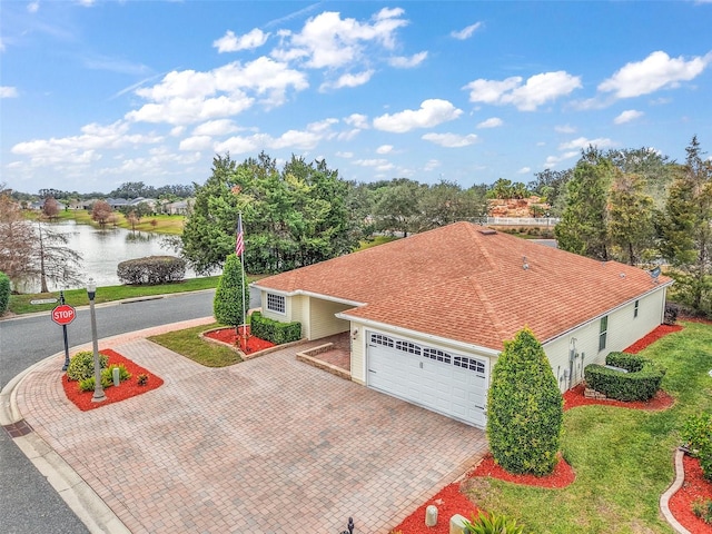 view of front facade with a water view, a garage, and a front lawn